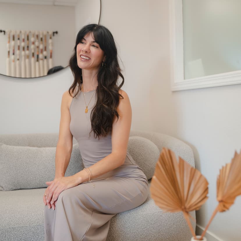 WOMAN SITTING ON COUCH SMILING